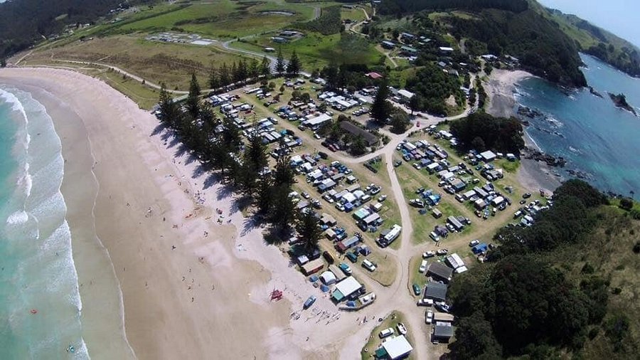 Matauri Bay Holiday Park spread along the beachfront, Matauri Bay surf spot, Northland East, New Zealand.