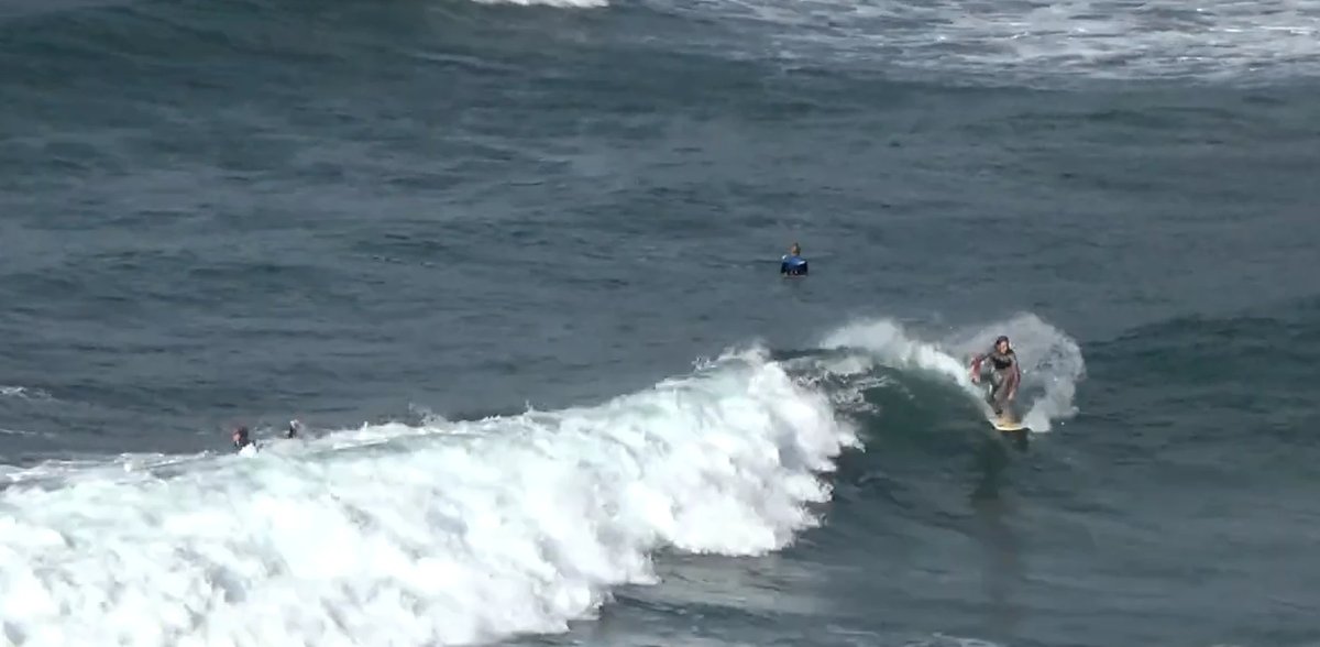 Surfers paddling out on a moody Great Barrier morning, Okiwi (GBI) surf spot, Auckland / Rodney, New Zealand.