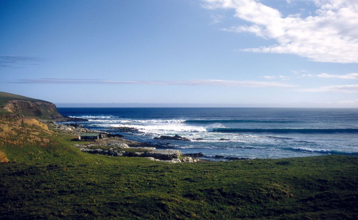 A lone hut sits above the reef on the remote Te Waewae Bay coast, the kind of place you only reach with a long walk across pr