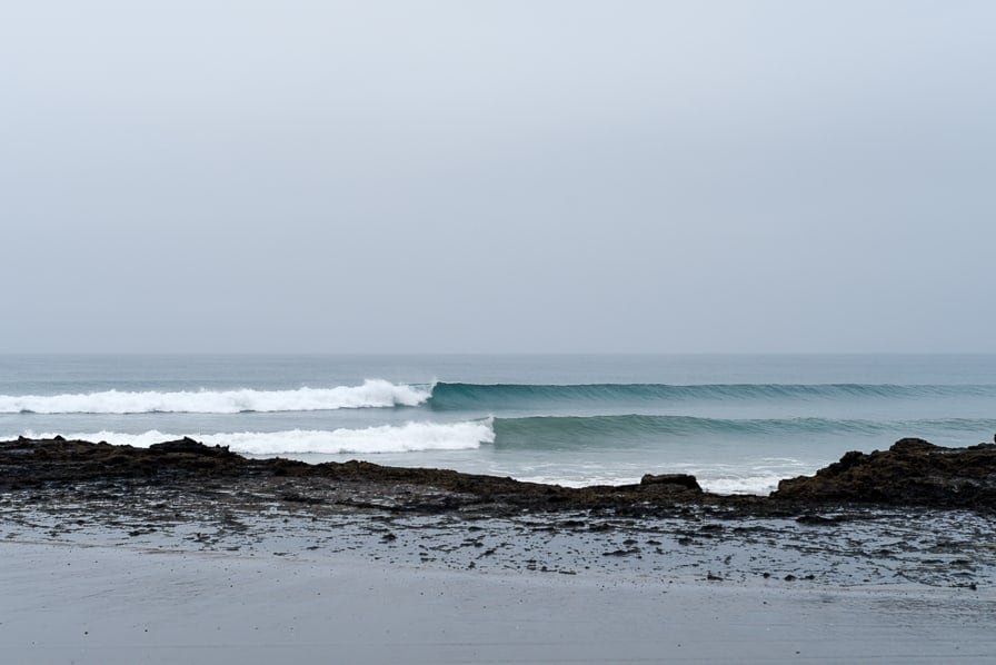 Moody afternoon at Wreck Bay, the point shaping up, Tauroa / Shipwreck Bay surf spot, Northland West, New Zealand.