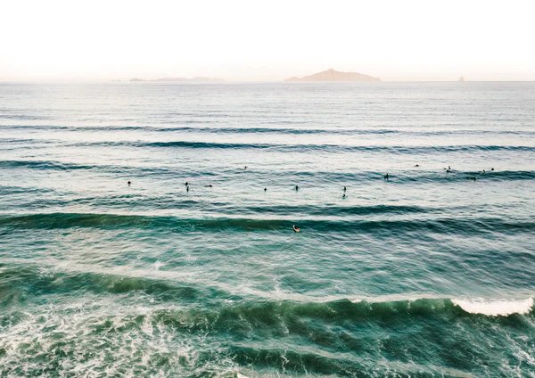 Locals out for an evening session, Waipū Cove surf spot, Northland East, New Zealand.